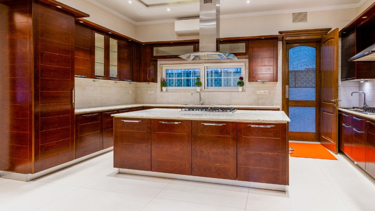 Spacious kitchen with wooden cabinets, an island and a range hood